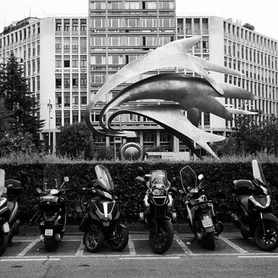 Stop near the building of motorcycle grayscale images
